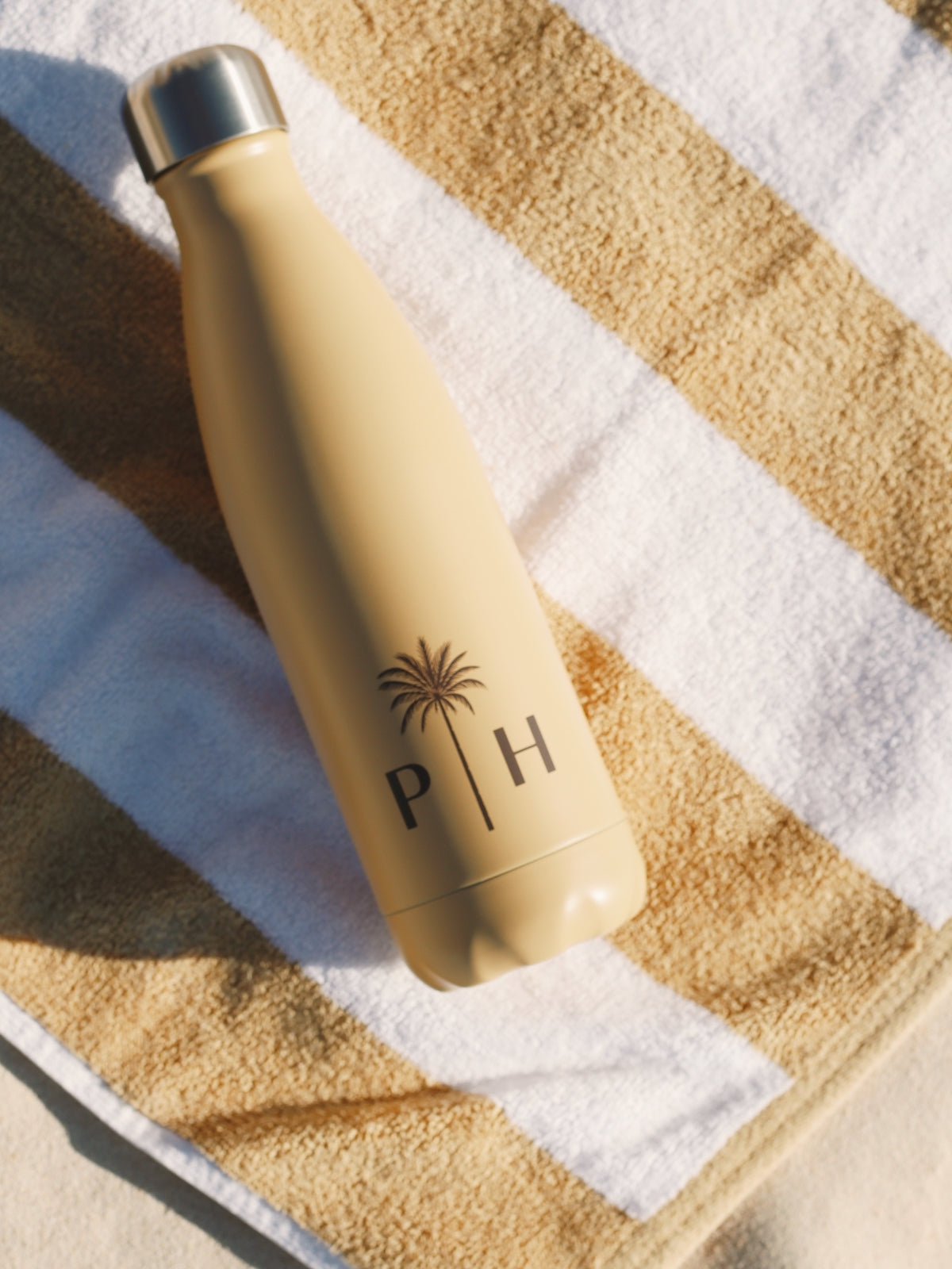 Palm Heights thermo bottle with tan striped beach towel